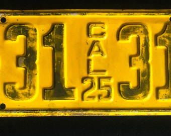 Könnte beinhalten: Ein gelbes Nummernschild aus Metall mit schwarzen Buchstaben. Das Schild lautet "C-31 CAL 25 314".