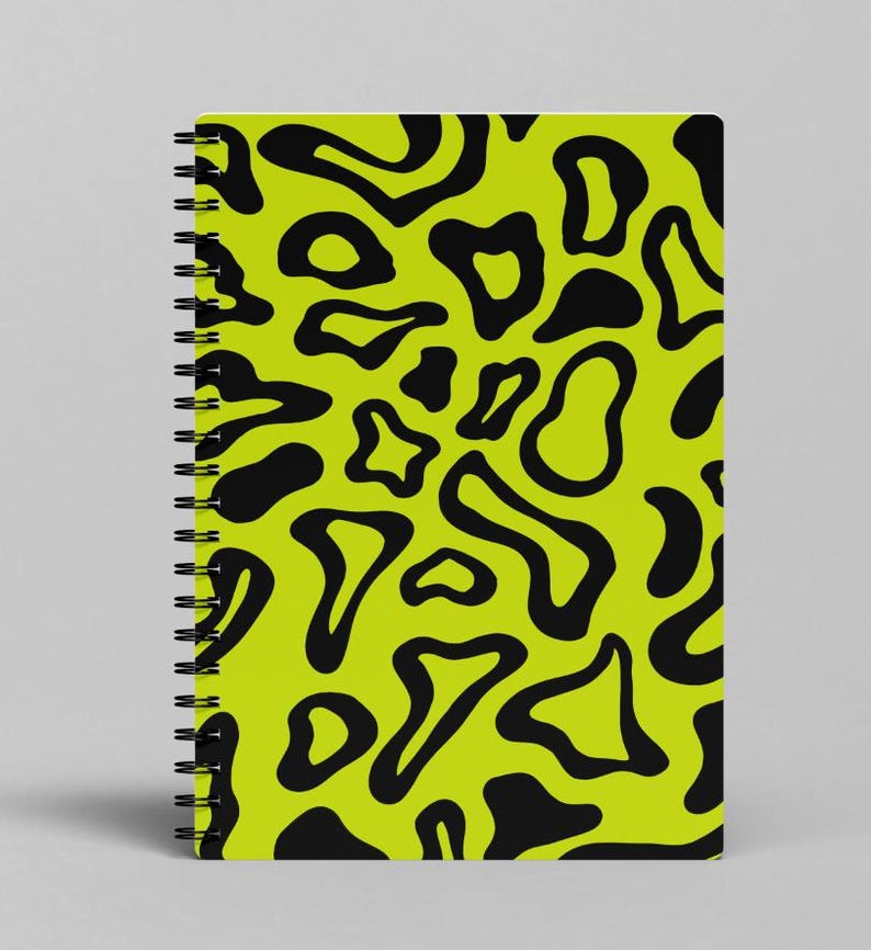 May include: A lime green spiral notebook with a black abstract pattern of irregular shapes.