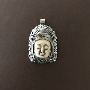 Bone buddha face pendant, repousse silver, floral back and front edge, handcrafted, Nepalese