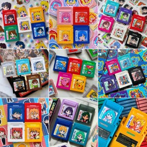 May include: A collection of colorful Game Boy cartridges featuring anime-style character art. The cartridges are in various colors, including red, yellow, blue, and green, with the text "GAME PAL" and "GAME BAND" visible. The artwork includes characters from popular anime series.