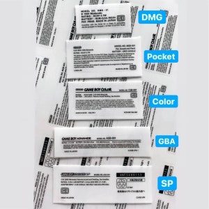 Puede incluir: Primer plano de etiquetas para diferentes modelos de Game Boy, incluyendo el Game Boy original, Game Boy Color, Game Boy Advance y Game Boy Advance SP. Las etiquetas son blancas con texto negro e incluyen números de modelo, información de la batería y otros detalles.