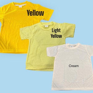 May include: Three plain t-shirts in different shades of yellow. The first is a bright yellow, the second is a light yellow, and the third is a cream color. Each shirt has a crew neck and short sleeves.