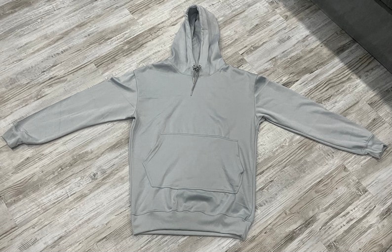 Op de afbeelding: Een lichtgrijs hoodie met een kangoeroezak.