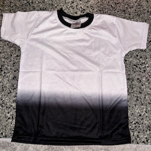 Könnte beinhalten: Weißes T-Shirt mit einem schwarzen Ombre-Effekt. Das Shirt hat einen schwarzen gerippten Rundhalsausschnitt.