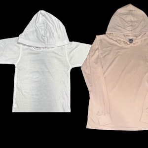 May include: Two long-sleeved hooded shirts, one white and one light pink.