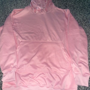 Op de afbeelding: Een lichtroze hoodie met een capuchon met trekkoord en een kangoeroezak.