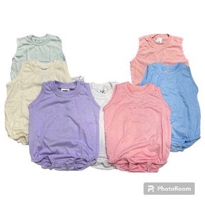 May include: Six sleeveless shirts in various pastel colors, including light blue, cream, lavender, pink, and white. The shirts are made of a soft, stretchy fabric and have a relaxed fit.