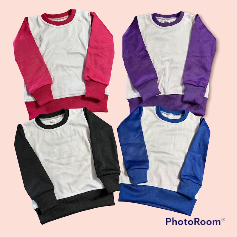 May include: Four crew neck sweatshirts in pink, purple, black, and blue. Each has a white body with contrasting sleeves and trim. The sweatshirts are displayed on a light pink background.