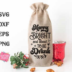 May include: A burlap wine bottle bag with the text "Merry Bright and about to be Drunk" printed on it. The bag is decorated with a small wine glass graphic and a sprig of leaves.