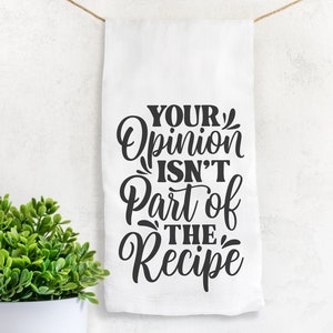 Puede incluir: Toalla de cocina blanca con texto negro que dice "Tu opinión no es parte de la receta".