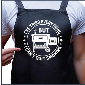 May include: A black apron with a white circle design that says "I've tried everything but I can't quit smoking" with a grill inside the circle.