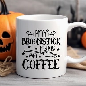 Peut inclure: Une tasse &agrave; caf&eacute; blanche avec du texte noir qui dit "My broomstick runs on coffee" avec une illustration noire et blanche d'un balai et d'&eacute;toiles.