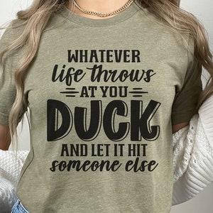 May include: A green t-shirt with the text "Whatever life throws at you - DUCK and let it hit someone else" printed in black.