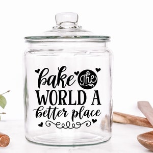 May include: A clear glass jar with a black and white design that says "bake the world a better place".