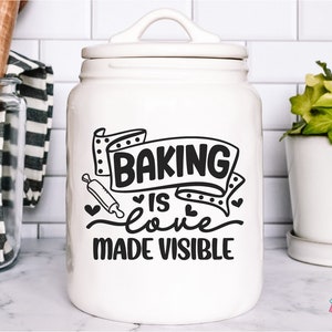 Puede incluir: Tarro de galletas de cerámica blanca con un diseño en blanco y negro que dice "Baking is love made visible".