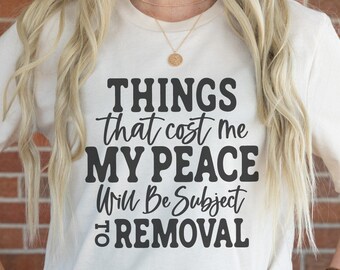 May include: A white t-shirt with black text that reads "THINGS that cost me MY PEACE Will Be Subject to REMOVAL".
