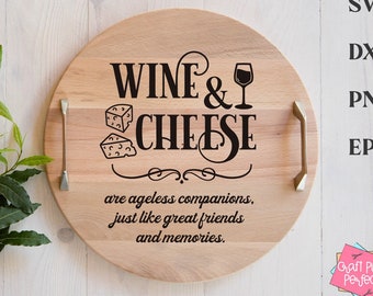 Peut inclure: Un plateau de service rond en bois avec une poignée dorée. Le plateau comporte un graphisme noir qui dit "Wine & Cheese are ageless companions, just like great friends and memories."