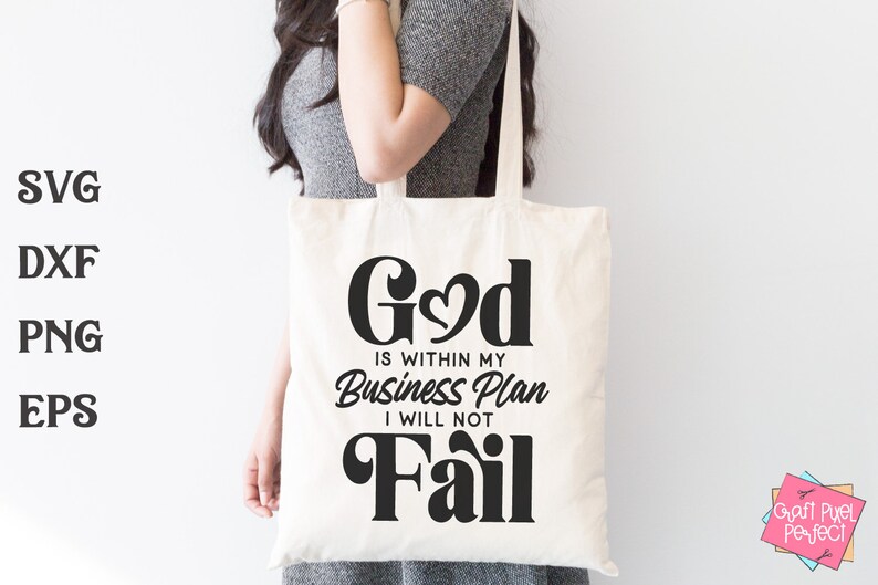 May include: A white tote bag with black text that reads "God is within my Business Plan I will not Fail". The text is in a stylized font with a heart in the middle of the word "God".