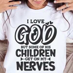 May include: White t-shirt with black text that reads "I love God but some of his children get on my nerves".