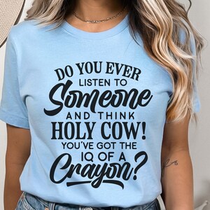 Może przedstawiać: Jasnoniebieska koszulka z czarnym nadrukiem "Do you ever listen to someone and think Holy Cow! You've got the IQ of a Crayon?"