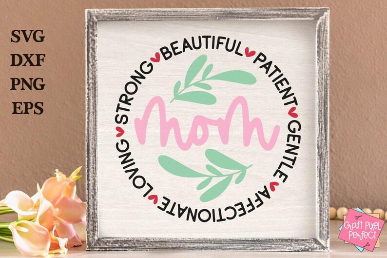 May include: A white sign with a pink circle in the center that says "Mom" in pink lettering.  The circle is surrounded by a black circle with the words "Affectionate, Loving, Strong, Beautiful, Patient, Gentle" in black lettering with red hearts between each word.