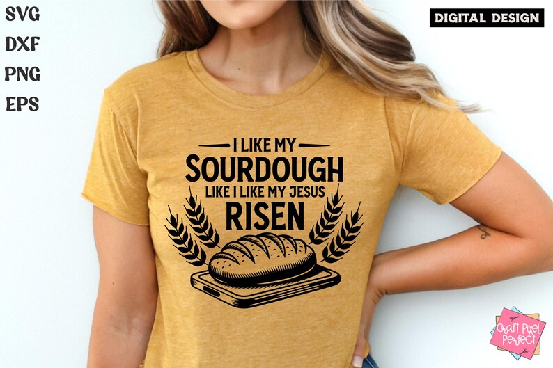 May include: A yellow t-shirt with a black graphic design that says "I like my sourdough like I like my Jesus risen". The graphic also includes a loaf of bread on a cutting board with wheat stalks on either side.