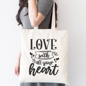 May include: A white tote bag with black text that reads "LOVE with all your heart". The text is in a decorative font with hearts and swirls around it.