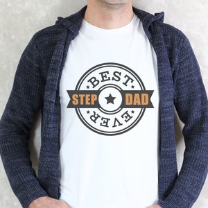 May include: A white t-shirt with a black and orange circular design that says "Best Step Dad Ever".