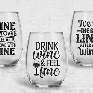 May include: Three clear wine glasses with black vinyl lettering. The first glass says "Wine Improves With Age I Improve With Wine". The second glass says "Drink Wine & Feel Fine". The third glass says "I've Got The Best Lines After A Few Wines".
