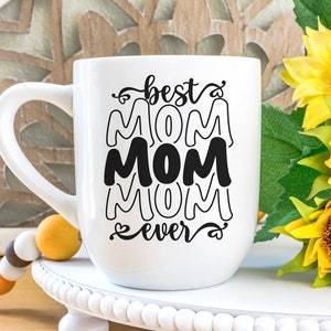 May include: White ceramic mug with a black design that says "best mom ever" with the word "mom" repeated three times in a stacked design.
