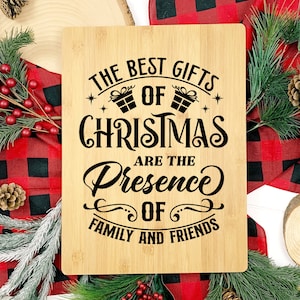 May include: A wooden cutting board with the text "The Best Gifts of Christmas Are The Presence of Family and Friends" in black lettering.