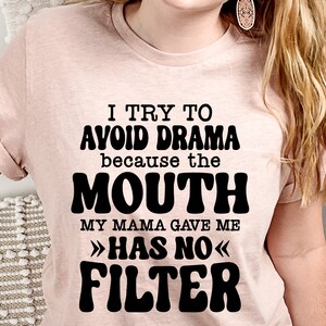 May include: A pink t-shirt with black text that reads "I try to avoid drama because the mouth my mama gave me >>has no<< filter".