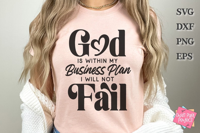 May include: A pink t-shirt with the text "God is within my Business Plan I will not Fail" in black lettering.