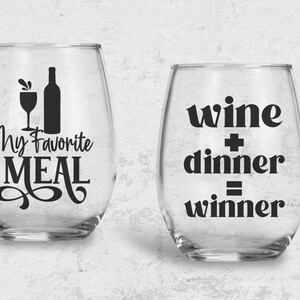 May include: Two clear wine glasses with black vinyl lettering. The first glass says "My Favorite Meal" with a wine bottle and glass silhouette. The second glass says "wine + dinner = winner".