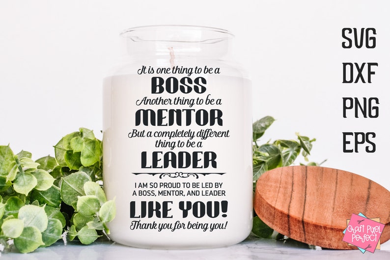 Op de afbeelding: Een witte kaars pot met een zwart tekstontwerp dat "It is one thing to be a BOSS. Another thing to be a MENTOR. But a completely different thing to be a LEADER. I am so proud to be led by a BOSS, MENTOR, and LEADER LIKE YOU! Thank you for being you!" zegt.