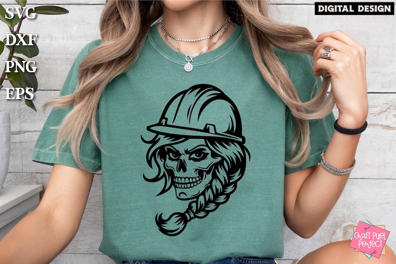 Op de afbeelding: Een zwart-wit grafisch ontwerp van een schedel met een helm op. De schedel heeft lang haar dat is gevlochten. Het ontwerp is op een groen T-shirt.