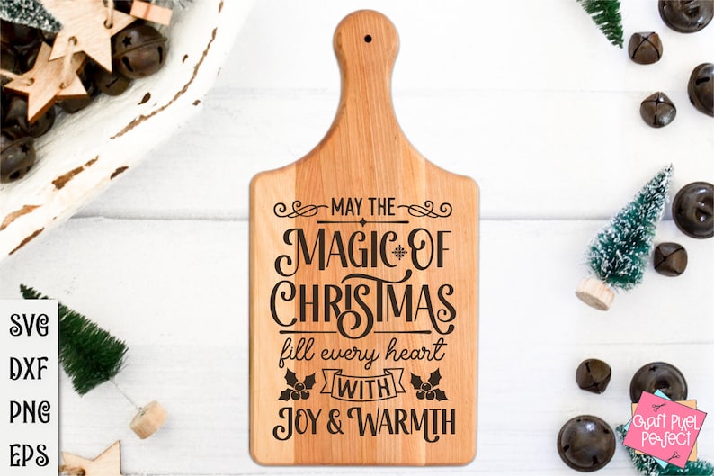 Puede incluir: Una tabla de cortar de madera con un dise&ntilde;o navide&ntilde;o. El texto dice "Que la magia de la Navidad llene cada coraz&oacute;n de alegr&iacute;a y calidez".
