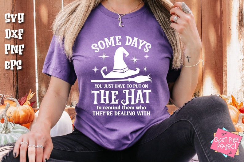 May include: Purple t-shirt with a white graphic of a witch's hat and the text "Some days you just have to put on the hat to remind them who they're dealing with."