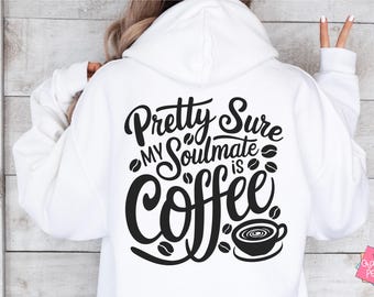 May include: White hoodie featuring the text "Pretty Sure My Soulmate is Coffee" in black script, along with coffee bean and cup graphics. A casual item of clothing.