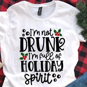 May include: White t-shirt with a black and green design that says "I'm not drunk I'm full of holiday spirit."