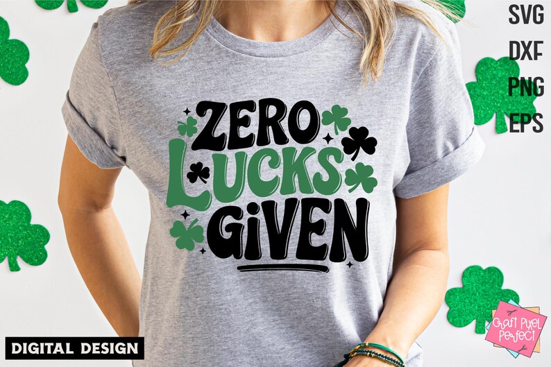 May include: A gray t-shirt with a green shamrock design and the text "Zero Lucks Given".
