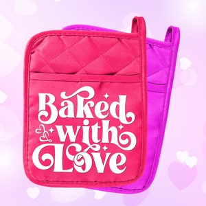 Może przedstawiać: Dwie różowe rękawice do piekarnika z białym pikowanym wzorem. Przednia rękawica ma napis "Baked with Love" w białym, stylizowanym foncie.