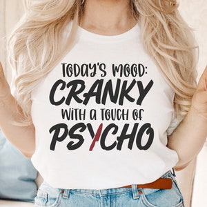 Puede incluir: Una camiseta blanca con texto negro que dice "Today's Mood: Cranky with a touch of Psycho".