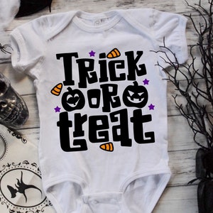 K&ouml;nnte beinhalten: Wei&szlig;er Baby-Strampler mit schwarzem Text "Trick or Treat" mit orangefarbenen und schwarzen Maisbonbons und K&uuml;rbisgrafiken.