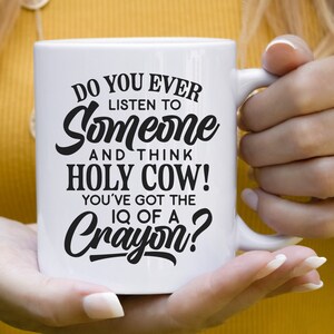 Może przedstawiać: Biały kubek ceramiczny z czarnym tekstem, kt&oacute;ry brzmi: "Do you ever listen to someone and think Holy Cow! You've got the IQ of a Crayon?"