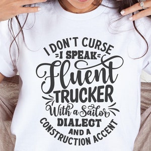 May include: White t-shirt with black text that reads "I don't curse = I speak - fluent trucker with a sailor dialect and a construction accent".