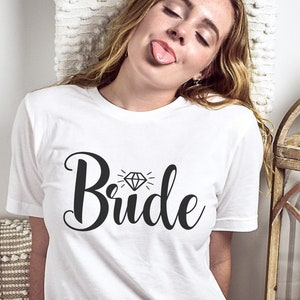 May include: White t-shirt with the word "Bride" in black script with a diamond graphic above the word.