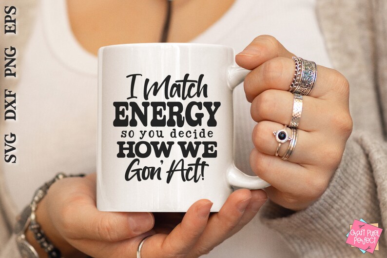 May include: White ceramic mug with the text "I Match ENERGY so you decide HOW WE Gon' Act!" in black. The mug is held by a person wearing multiple rings. The mug is a standard size for coffee or tea.