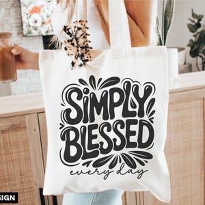 May include: A white tote bag with the words "SIMPLY BLESSED every day" in a black, stylized font. The bag is held by a person. The image also includes the words "SVG, DXF, PNG, EPS" and "DIGITAL DESIGN".
