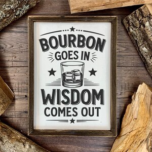 May include: A rustic wooden sign with black text that reads "Bourbon goes in Wisdom comes out". A black and white illustration of a glass of bourbon with ice cubes is in the center of the sign.